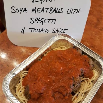 Vegan meatballs, served with spaghetti and tomato sauce with olives